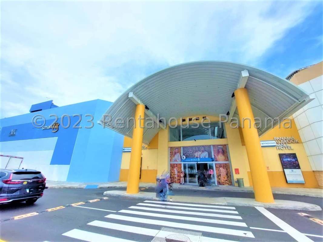 Main entrance Albrook Mall Panama with blue-yellow facade and signage for mall and Wyndham hotel