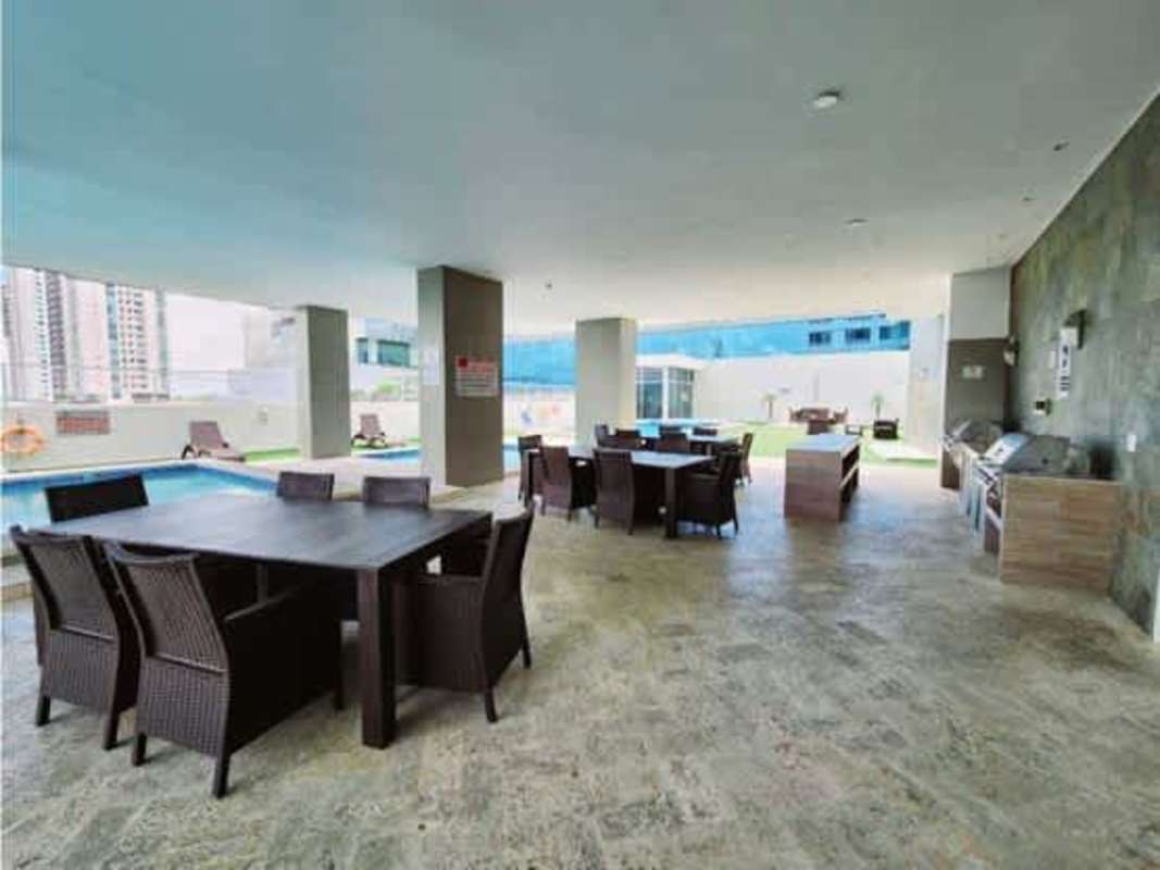Covered outdoor lounge with dining tables, barbecue, swimming pool in PH Titanium Tower Costa del Este Panama