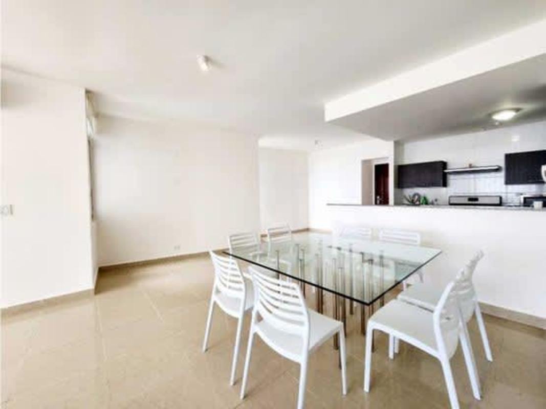 Dining space facing open-plan kitchen with granite, dark cabinetry PH Titanium Tower Costa del Este Panama