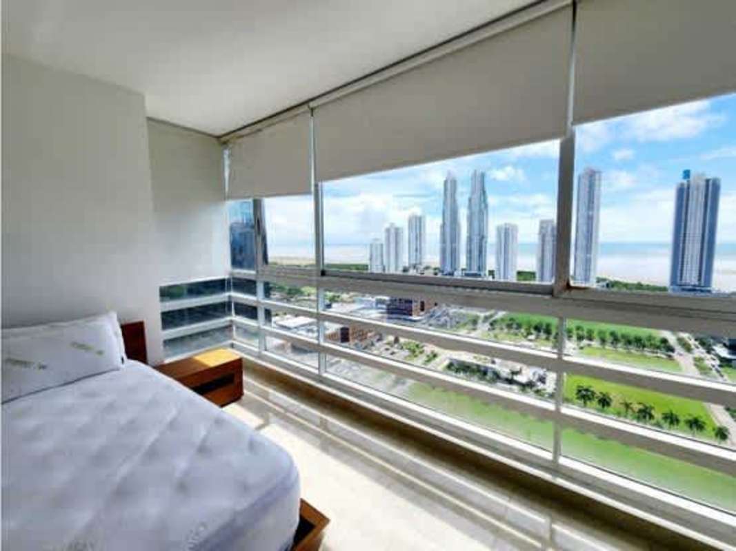 Modern bedroom with panoramic windows, city skyline and ocean views PH Titanium Tower Panama
