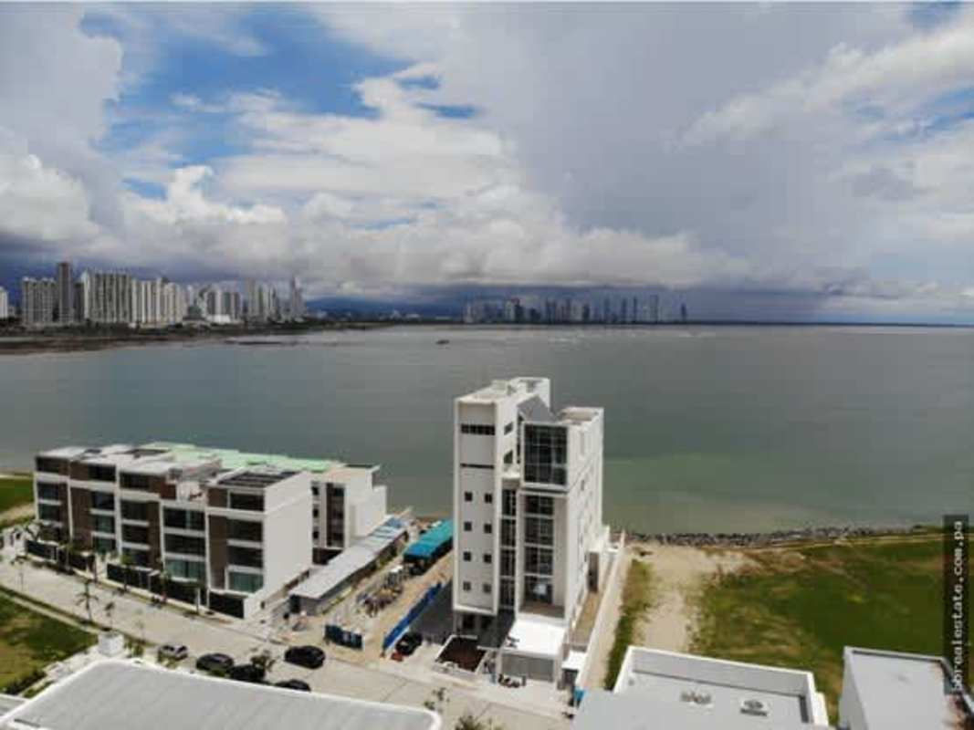 Spacious open-concept living and dining room with floor-to-ceiling windows and panoramic marina views