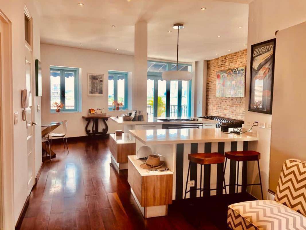 Open plan loft kitchen with exposed brick and island in PH Jeronimo Casco Viejo for sale