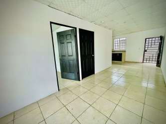 Minimalist kitchen with granite countertop, dark cabinets, window with grille in David Chiriquí rental