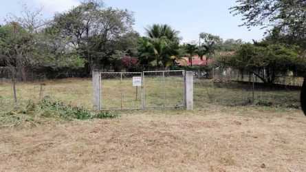 Entrance gate leading to large flat cleared lot with trees Playa Coronado Panama