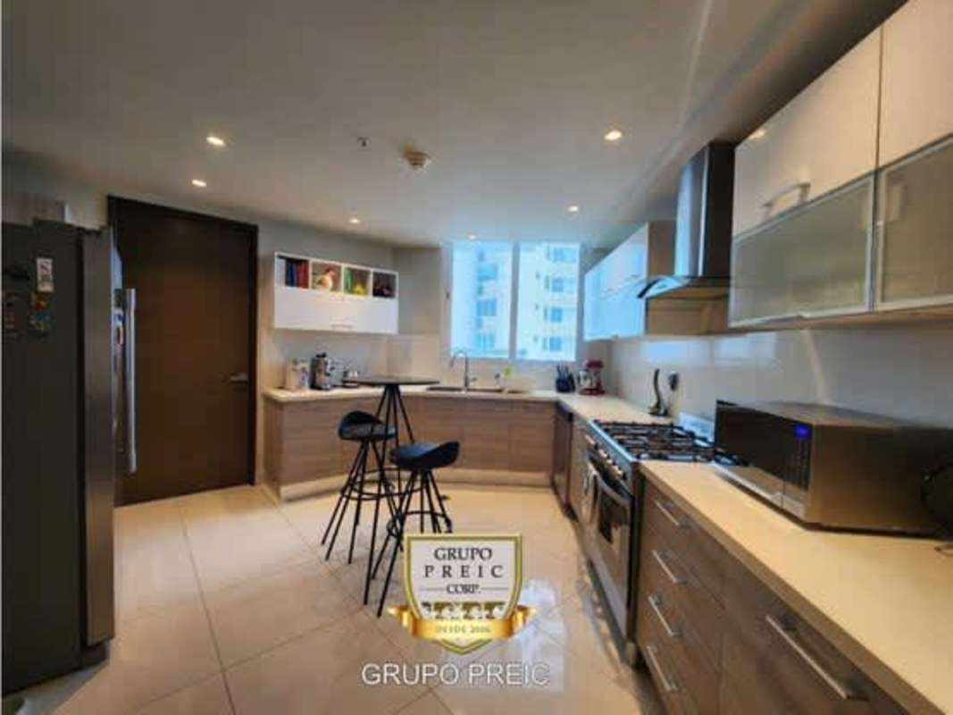 Modern kitchen with stainless steel appliances and light wood cabinets in Costa del Este