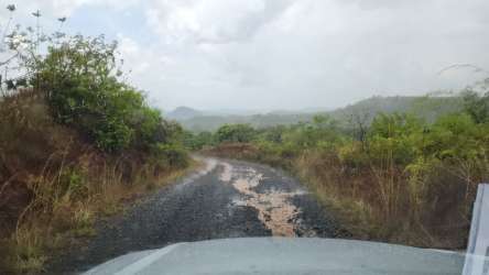 Rustic dirt road amidst countryside green shrubs and hills in San Francisco sector Las Tablitas Panama