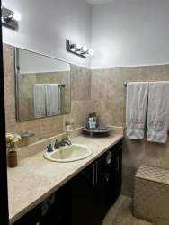 Modern kitchen with wood cabinetry, granite counters, stainless steel appliances in Vista Mar villa San Carlos Panama