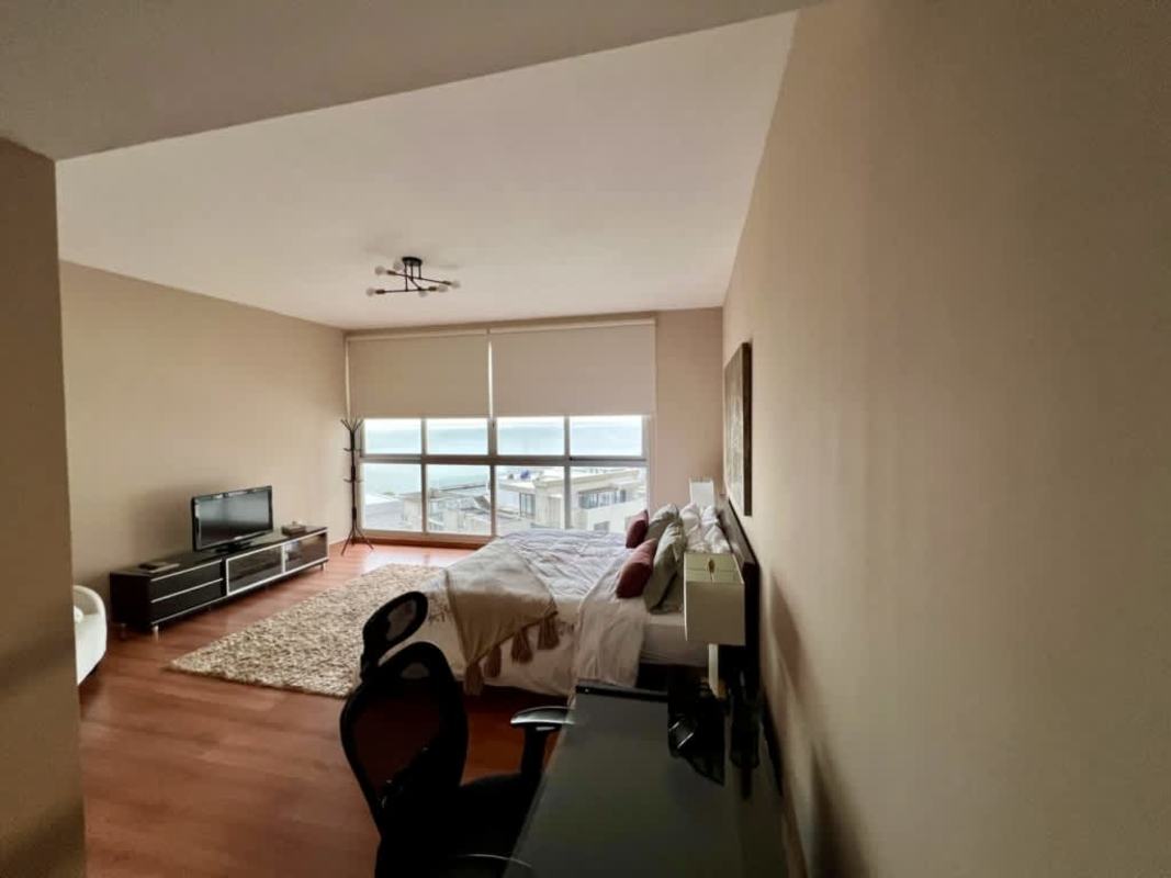 Minimalist bedroom with TV, large window and city view in Punta Pacifica Panama