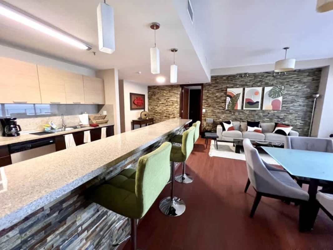 Contemporary kitchen with granite counters and dining space in PH Ocean Club Panama