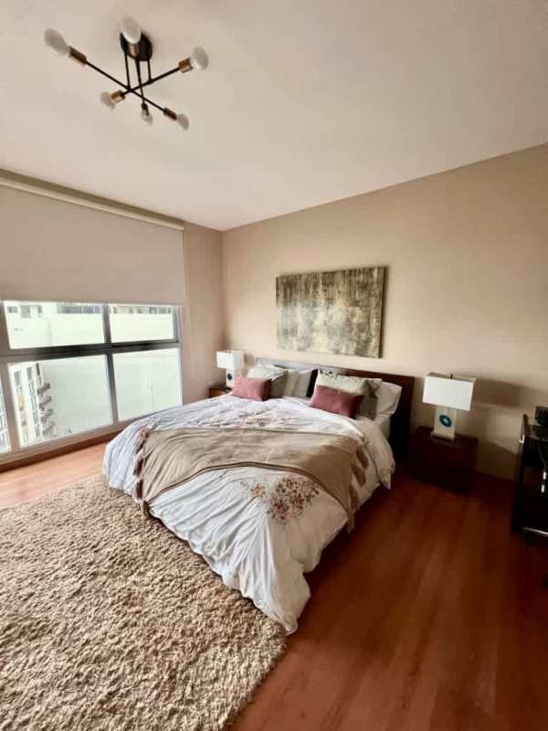 Bedroom with floor-to-ceiling windows overlooking Pacific Ocean and skyline in Punta Pacifica