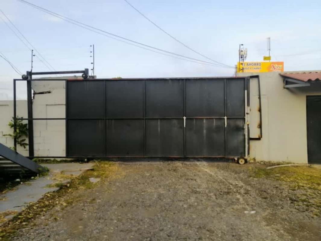 Vacant land with green vegetation adjacent urban street corner Panama City