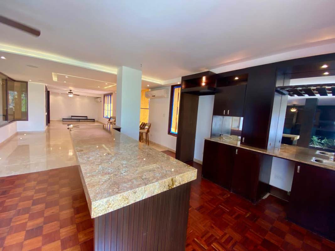 Modern kitchen with granite countertops, dark cabinetry and center island in PH Sobre Las Rocas Coco del Mar Panama