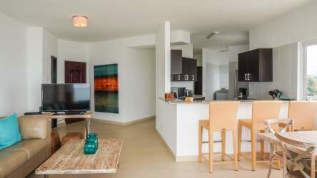 Open kitchen with granite bar, appliances and dining space in beachfront apartment PH Patricia Italia