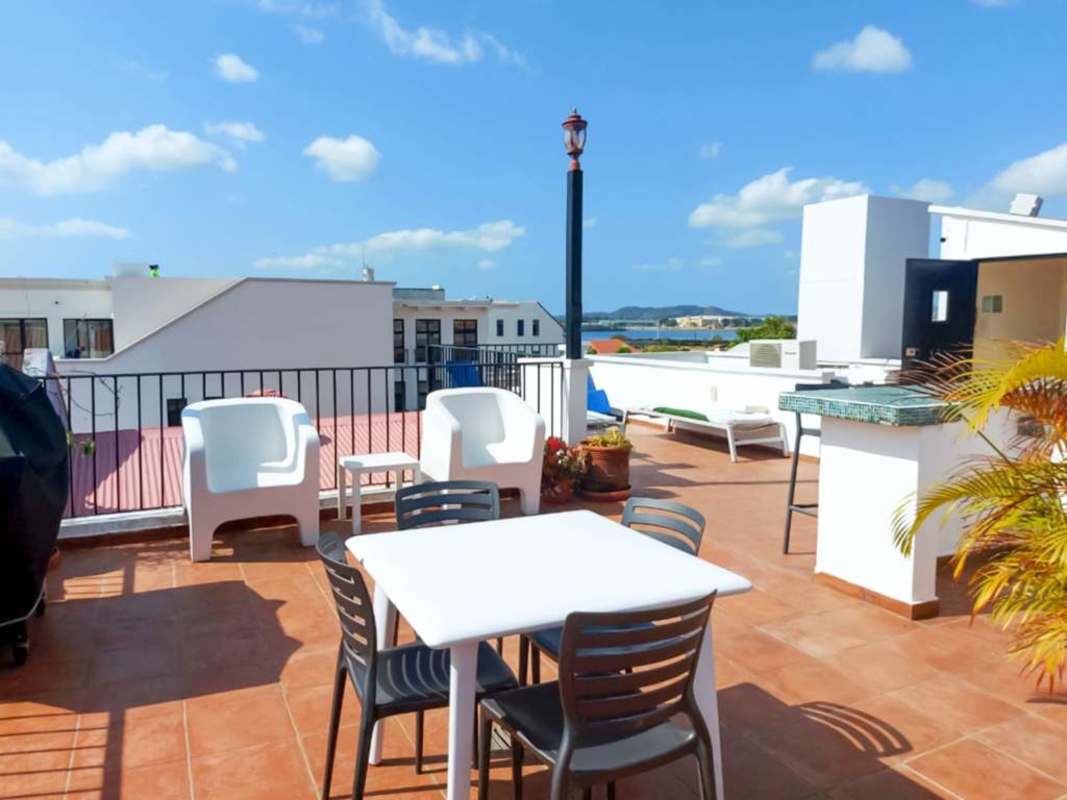 Curved balcony with iron railing overlooking Casco Viejo colonial roofs in Panama City