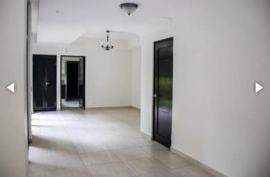 Hallway with ceramic tiles, white walls, and black doors in Nativa Panama Pacifico house