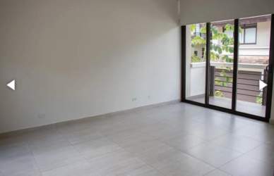 Large tiled living room with glass sliding doors opening to terrace in Nativa Panama Pacifico