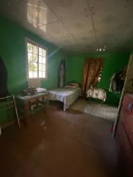 Bedroom with green walls, window with curtains and tiled floor in budget rental Arraiján