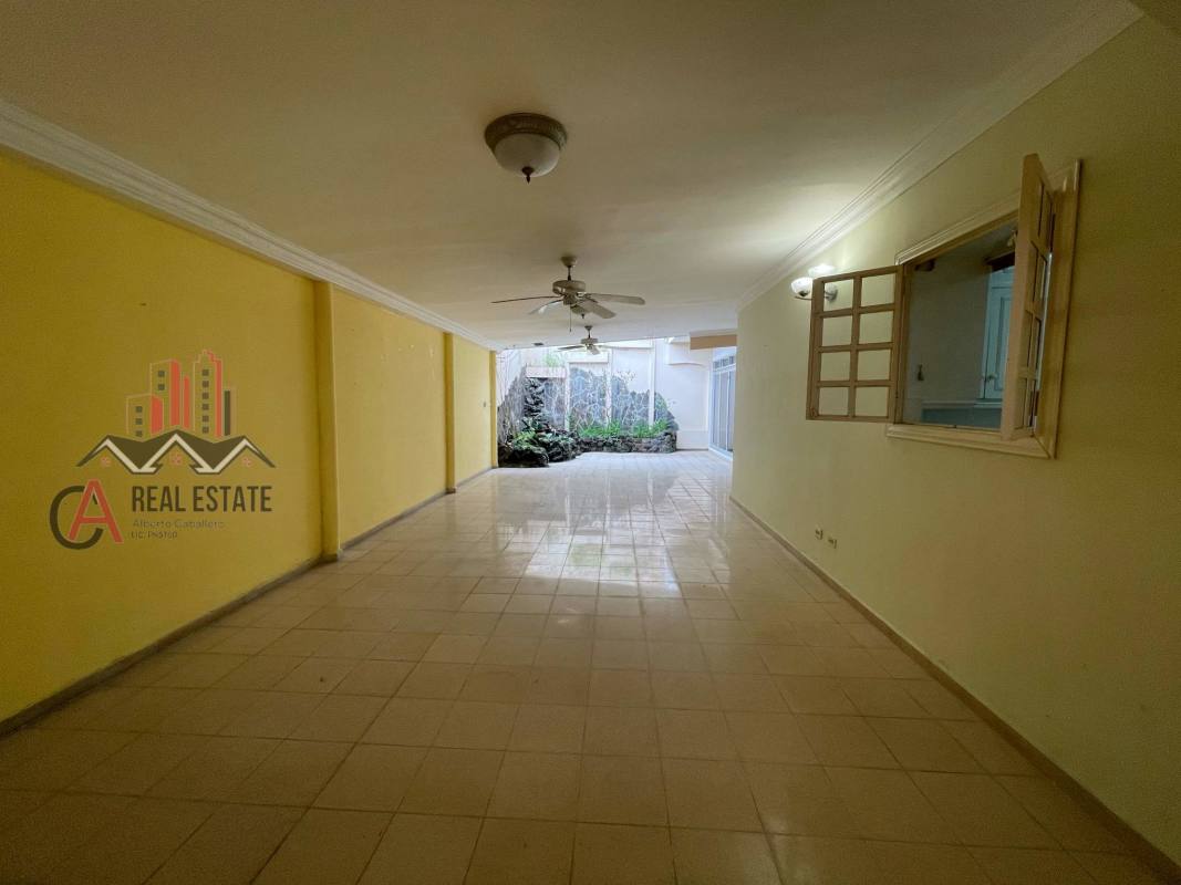 Covered garage with yellow walls, tiled floor and gate at home in Las Mercedes Betania Panama