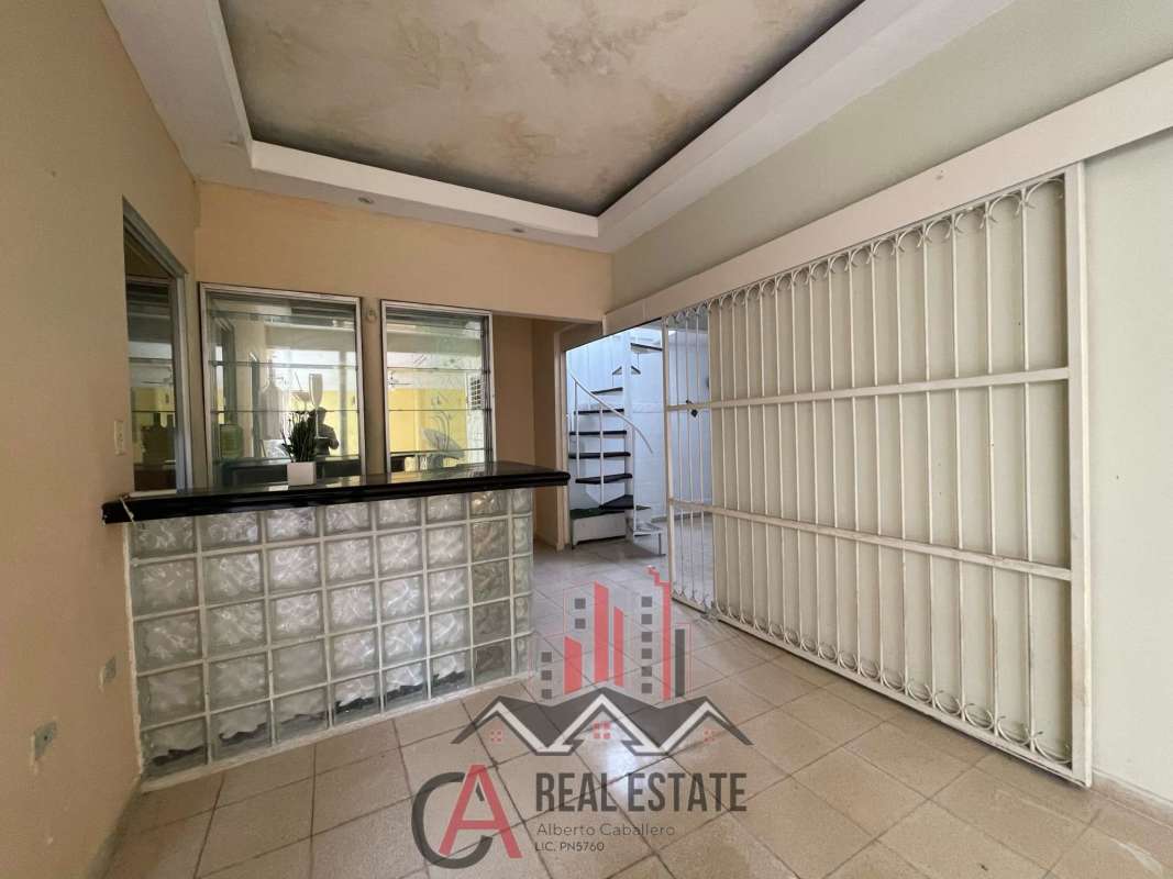 Long enclosed sunroom patio with tile floor, yellow walls and ceiling fan in Las Mercedes home Panama
