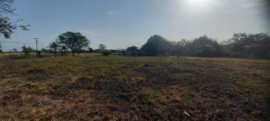 View of paved road alongside open flat land corner lot in Punta Barco near Coronado beaches Panama