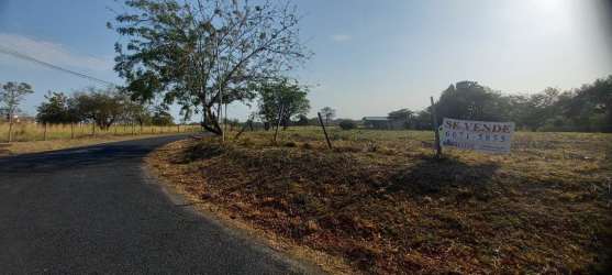Vacant lot bordered by curved paved road, near beaches, trees and clear sky Punta Barco Panama