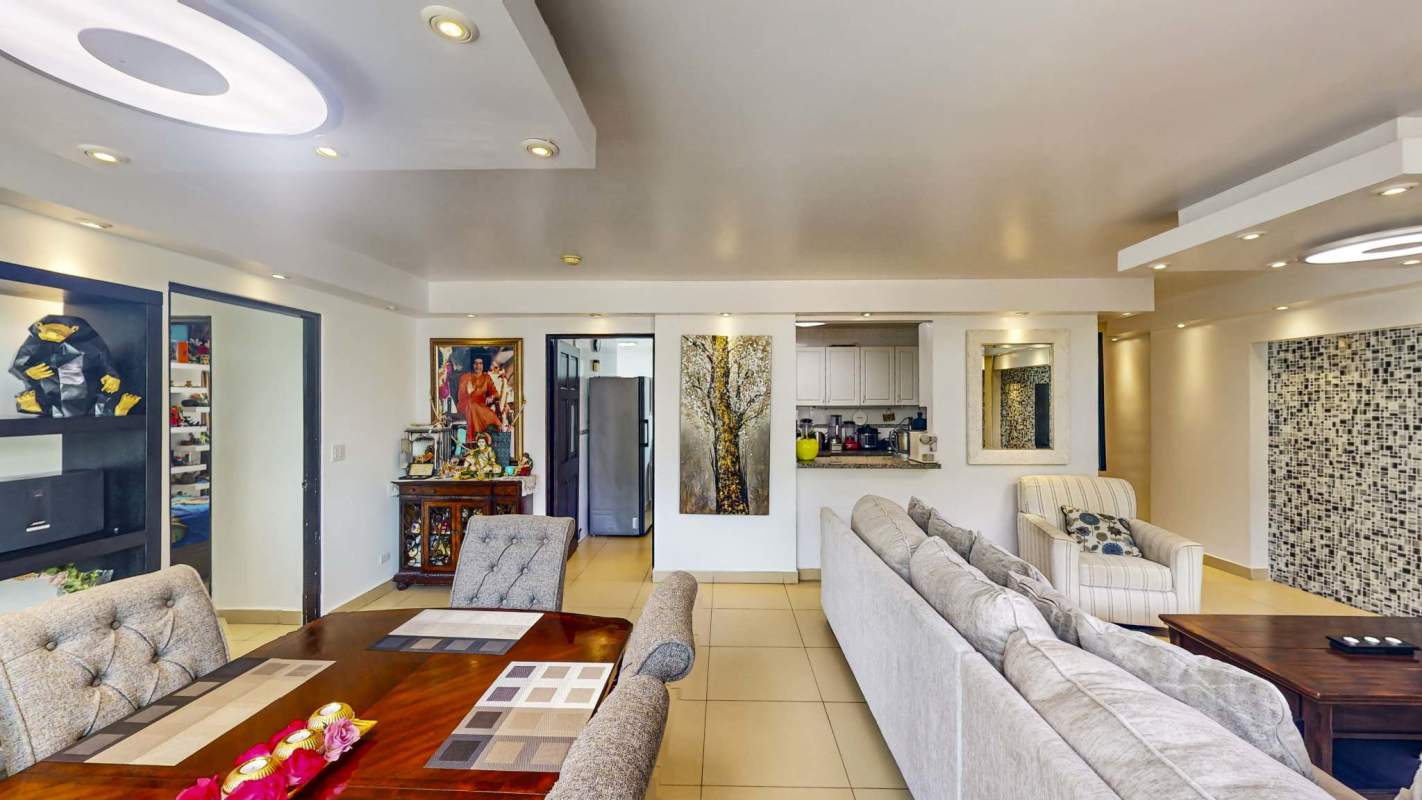 Contemporary open living area with floor to ceiling windows, dining table, sectional sofa in Edison Park Panama