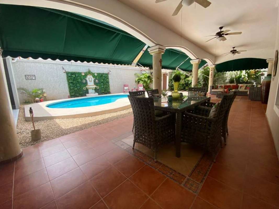 Mediterranean-style covered patio with outdoor dining area and garden in Costa de las Perlas Panama City