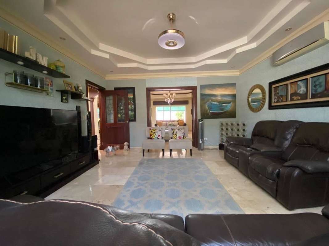 Bright living room with marble flooring, large sofas and elegant decor in Costa del Este residence Panama