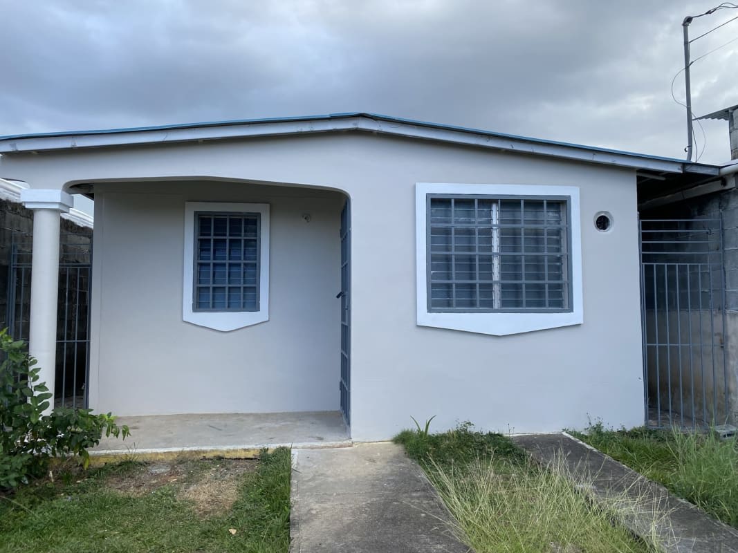 Single-story house with front porch, security bars, fenced garden at Altos de San Ángel