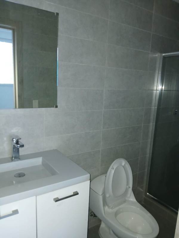 Contemporary bathroom with gray tile, vanity and glass shower in Signature Point Panama City