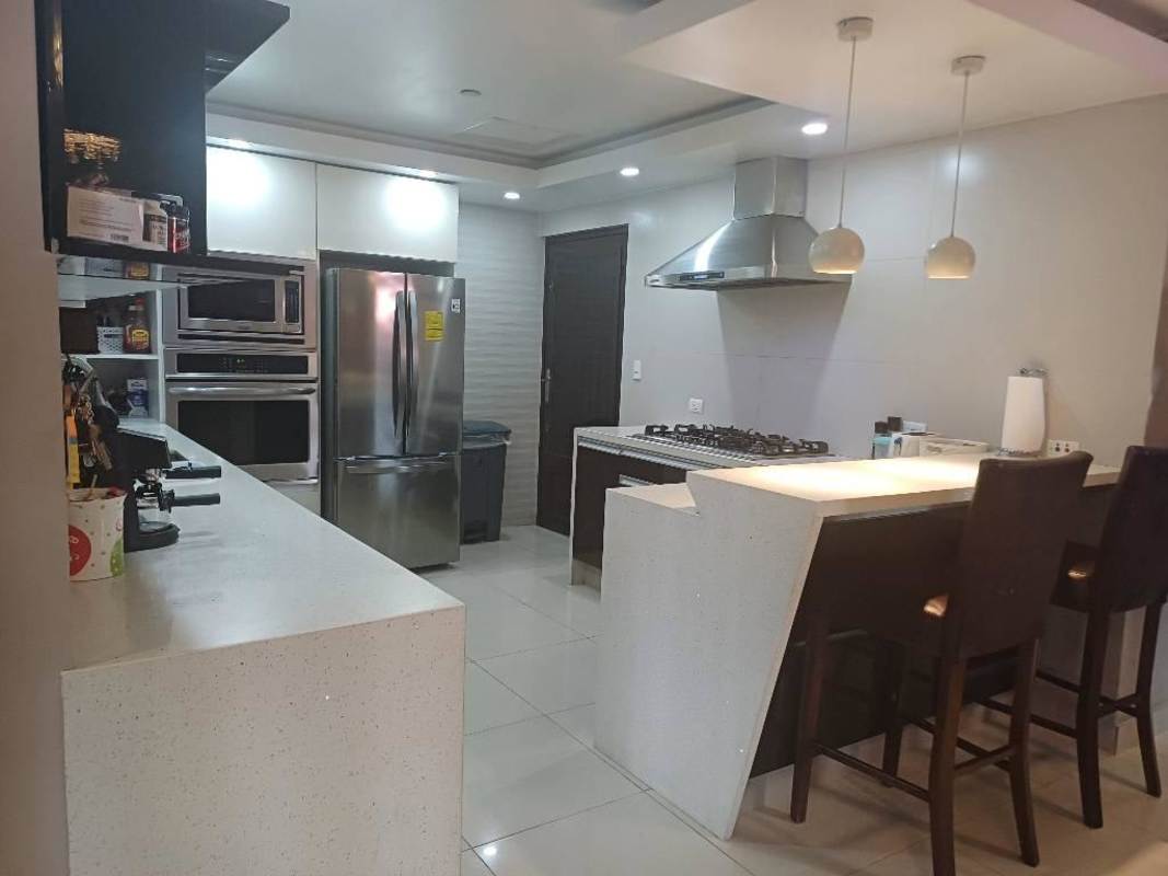 Remodeled kitchen with brown cabinetry, breakfast bar, appliances for sale in Altos del Chase El Dorado