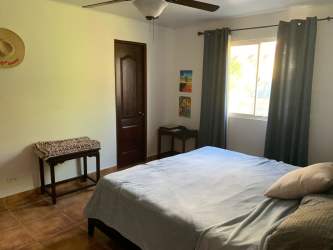 Bedroom with blue bedding AC ceiling fan window Playa Blanca real estate