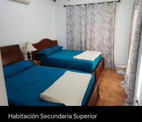 Traditional bedroom two beds wood furniture ceiling fan Playa Blanca house Panama