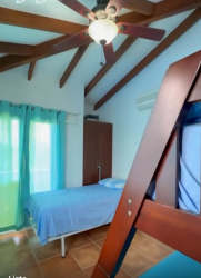 Bedroom with ceiling beams, tile floors, ceiling fan and bunk beds Playa Blanca beach home