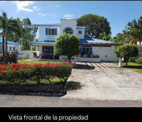 White facade two-story house with blue roof and landscaped garden Playa Blanca Panama