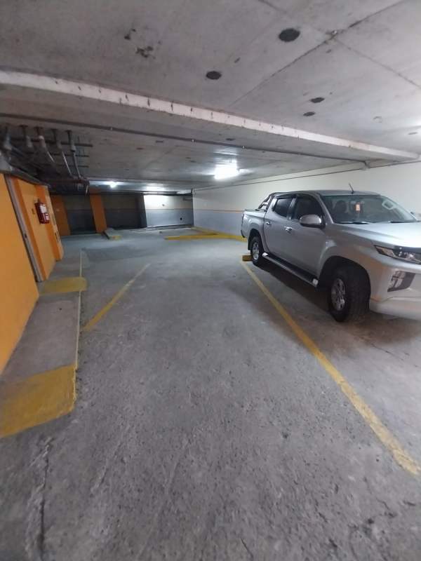 Modern minimalist kitchen with dark cabinetry, tile floor, stainless refrigerator and ceiling fan in PH Altavista Tower Panama