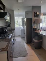 View of open kitchen with granite counter and adjacent dining area PH Ciudad del Futuro