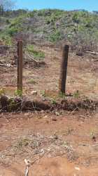 Undeveloped sloped countryside land with wooden fence posts on 6 hectares in Santa Rita La Chorrera Panama