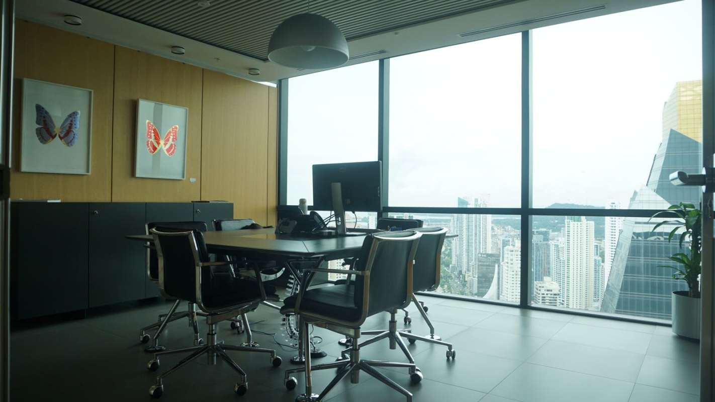 Large modern conference room with table, chairs and floor-to-ceiling windows overlooking Panama City