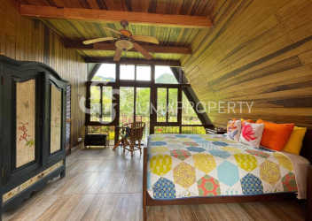 Twin bedroom with large window, wooden decor, and garden view Panama mountain property