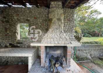 Stone outdoor fireplace with chimney under wooden roof mountain view Panama Valle de Antón