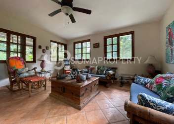 Enclosed sunroom with large windows overlooking mountains and lush foliage in Valle de Antón Panama