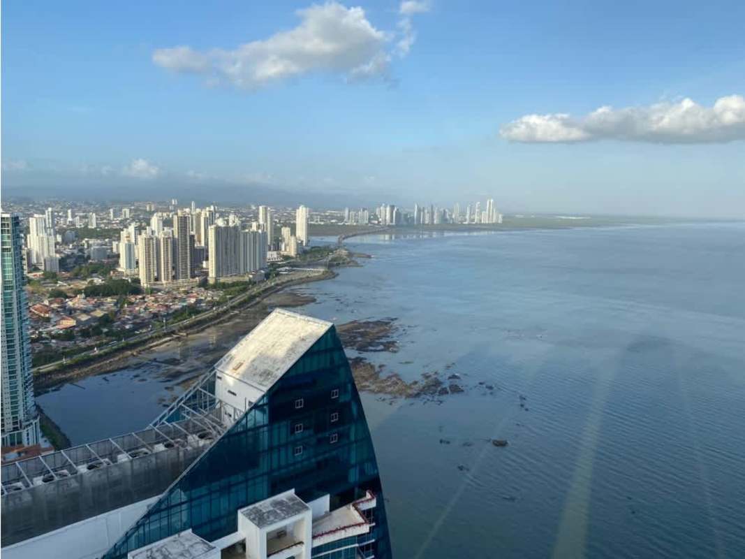 Modern living area with large floor-to-ceiling windows and ocean city views