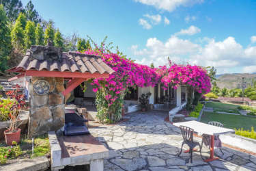 Mediterranean style patio surrounded by pink bougainvillea flowers and mountain valley views at Altos del Maria