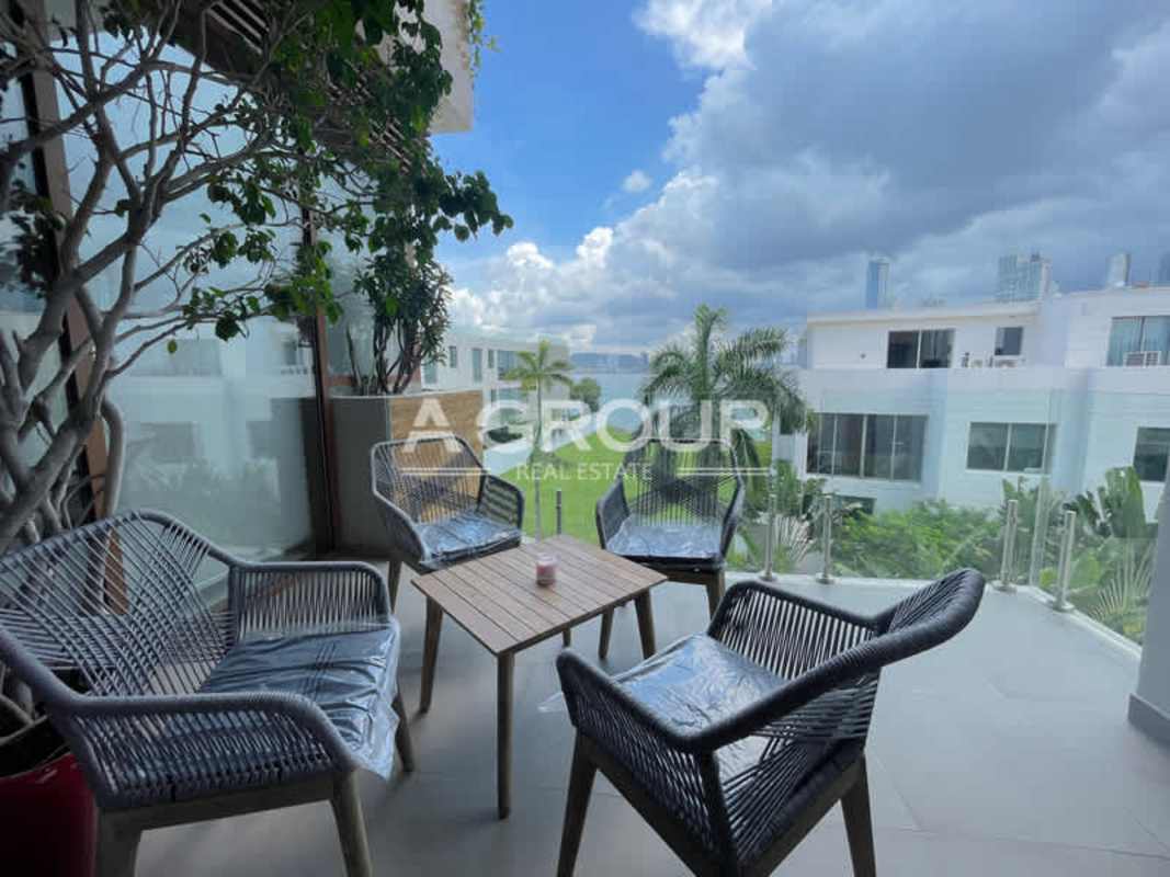 Contemporary open dining area with glass table connected to modern luxury kitchen in Ocean Reef Islands apartment Panama