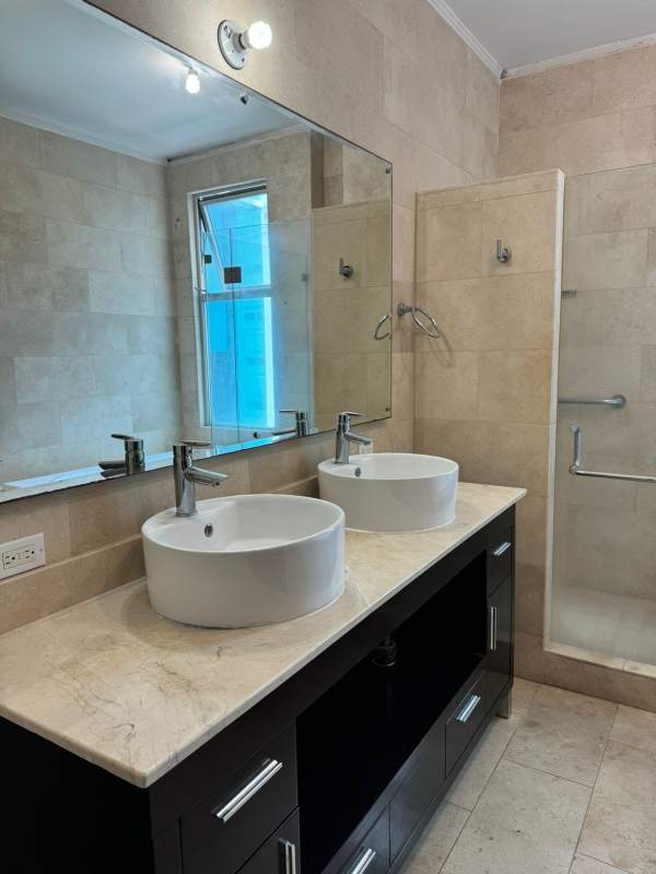Luxury bathroom with double vessel sinks, glass shower at Pacific Village Panama