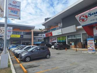 Ample parking area with commercial storefronts Plaza Los Naranjos Penonomé Panama