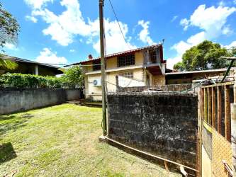Front of rustic countryside home with palm trees, garden and covered parking in Nuevo Emperador Panama