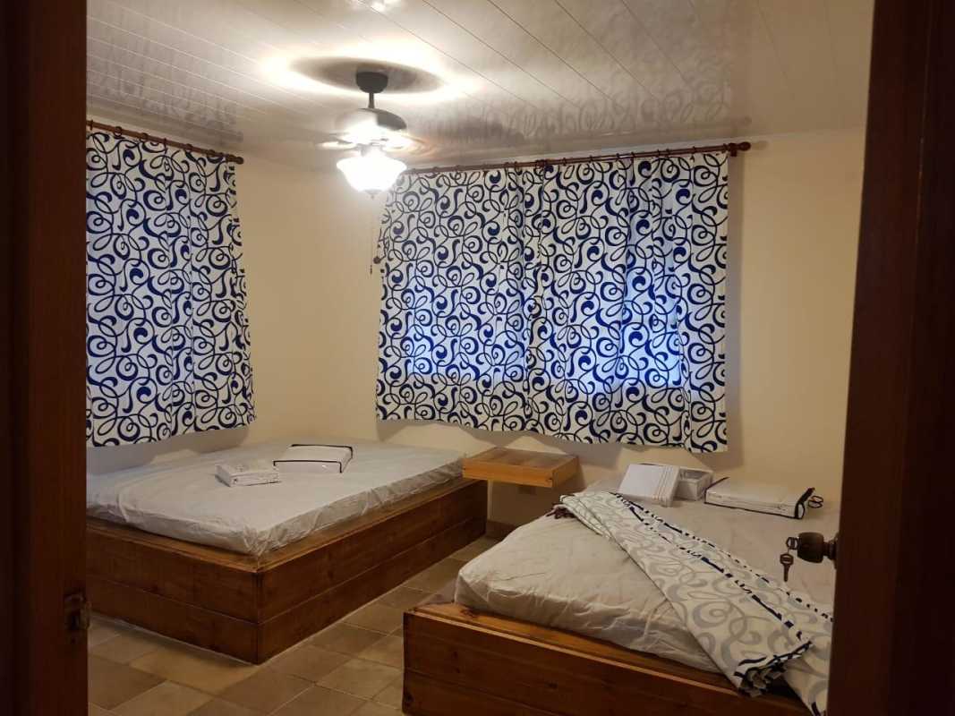 Bedroom with two single wooden beds, tile floor, and closet in Altos de Cerro Azul Panama