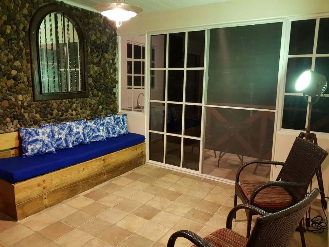 Sunroom enclosed terrace with blue cushions and garden view in Cerro Azul Panama